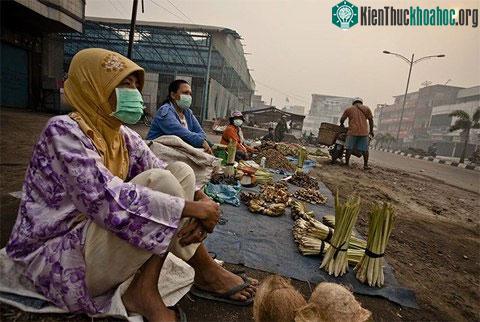 Tiểu thương đeo khẩu trang trong lúc bán hàng ven đường.