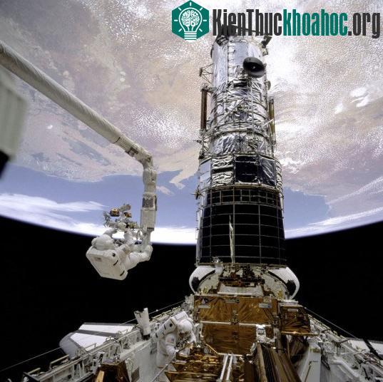 Phi hành gia Story Musgrave (trên) và Jeffrey Hoffman (dưới) đáp xuống vị trí của kính viễn vọng không gian Hubble cỡ lớn.