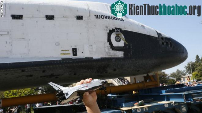 Một bé trai cầm mô hình tàu Endeavour bên cạnh con tàu này - (Ảnh: Getty Images)