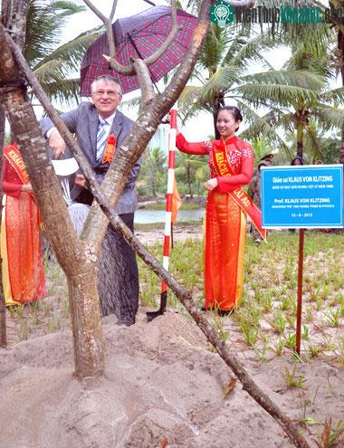Giáo sư Klitzing, nhà vật lý người Đức được trao giải Nobel năm 1985, trồng cây lưu niệm trong khuôn viên trung tâm khoa học quốc tế và giáo dục liên ngành sáng 12/8. (Ảnh: Trí Tín)