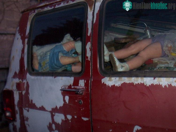 Lớp sơn đỏ bị tróc loang lổ như máu, bên trong là những con búp bê nằm ngổn ngang