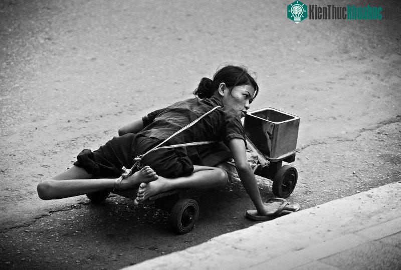 Một người tàn tật đi ăn xin dọc theo vỉa hè Sài Gòn, 1980.