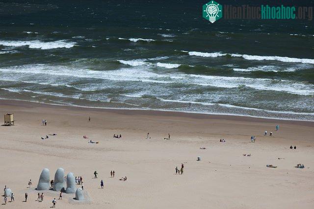 Bàn tay ngập trong cát ở Maldonado, Uruguay.