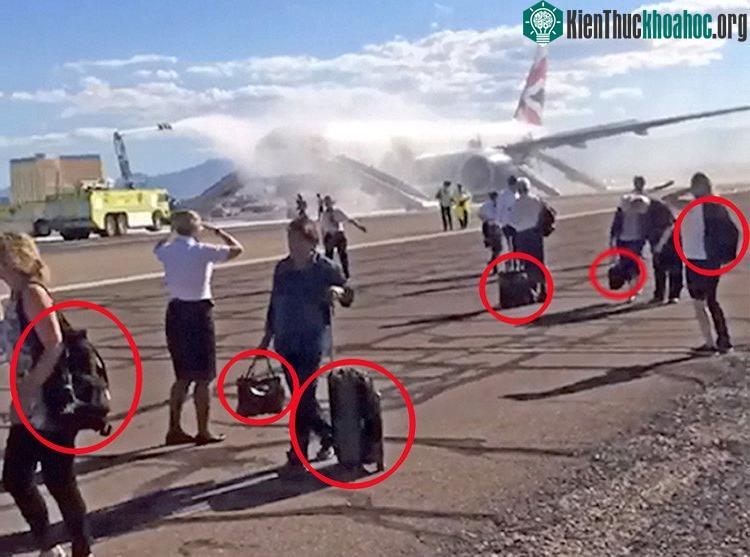 Nhiều hành khách vẫn cố lấy hành lý trước khi thoát khỏi máy bay hãng British Airways. (Ảnh: Metro).