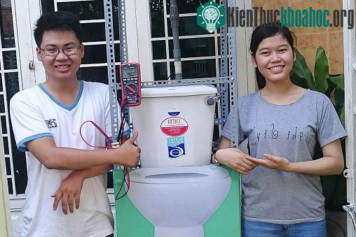 Tín và Thanh bên cạnh mô hình “Máy phát điện mini và pin tạo điện từ nước tiểu”.