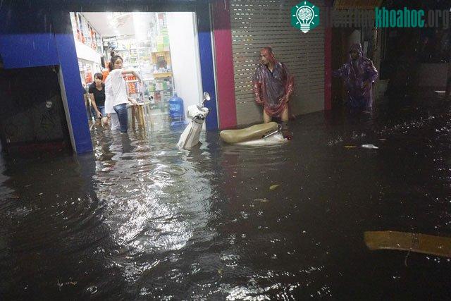 Nước tràn vào một hiệu thuốc, các nhân viên tại đây phải vất vả chạy hàng.