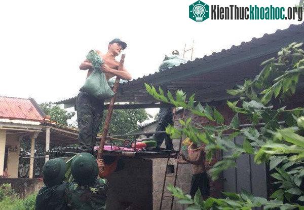 Chèn mái nhà trong mưa bão. (Ảnh: Hoàng Táo).