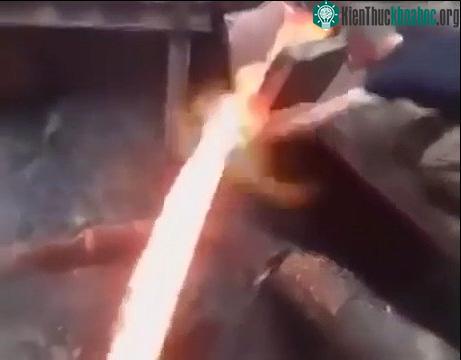 Một người đàn ông dùng tay không cắt ngang dòng kim loại nóng chảy mà không bị thương.