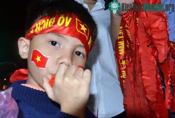 Bé trai mang theo kèn để mừng chiến thắng đội tuyển U23