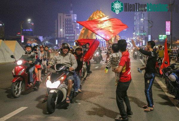 Một người dân bồng theo con nhỏ ra đường ăn mừng chiến thắng của đội tuyển.