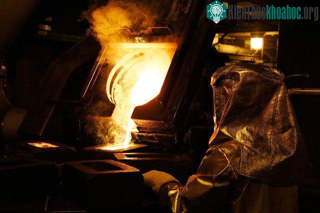 Kỹ thuật viên xử lý vàng lỏng thành vàng miếng - (Ảnh: REUTERS).