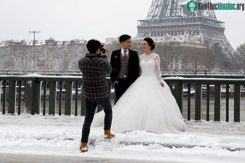 Một cặp đôi chụp ảnh cưới trên cầu Bir-Hakeim trong trời tuyết.