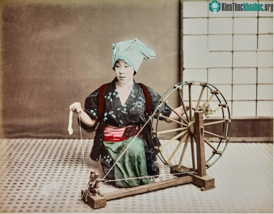 Một phụ nữ đang ngồi dệt vải.