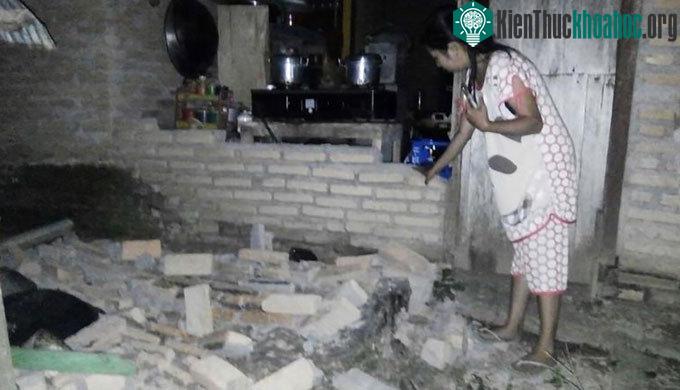 Một người dân chỉ vào bức tường gạch đổ nát trong nhà tại làng Tobadak ở Trung Mamuju, phía tây tỉnh Sulawesi
