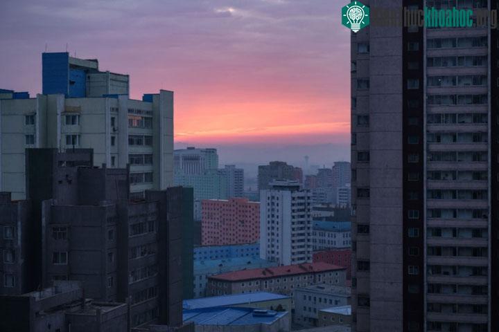 Một người đàn ông đứng trên tầng cao nhất của Khải Hoàn Môn, quan sát khung cảnh Bình Nhưỡng.