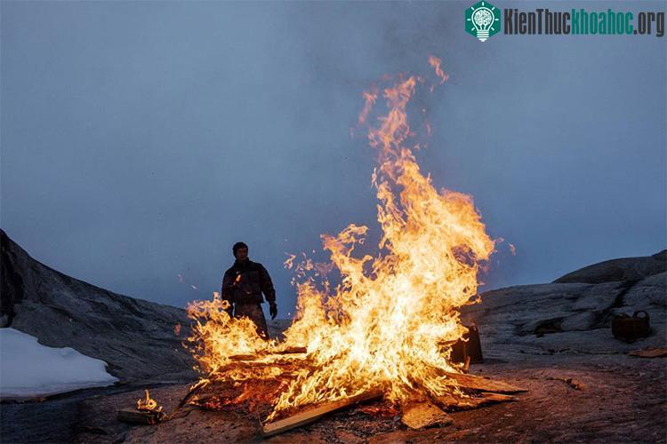 Sinh viên Febin Magar nhìn đống lửa thiêu đốt số gỗ còn sót lại trong một trại nghiên cứu.