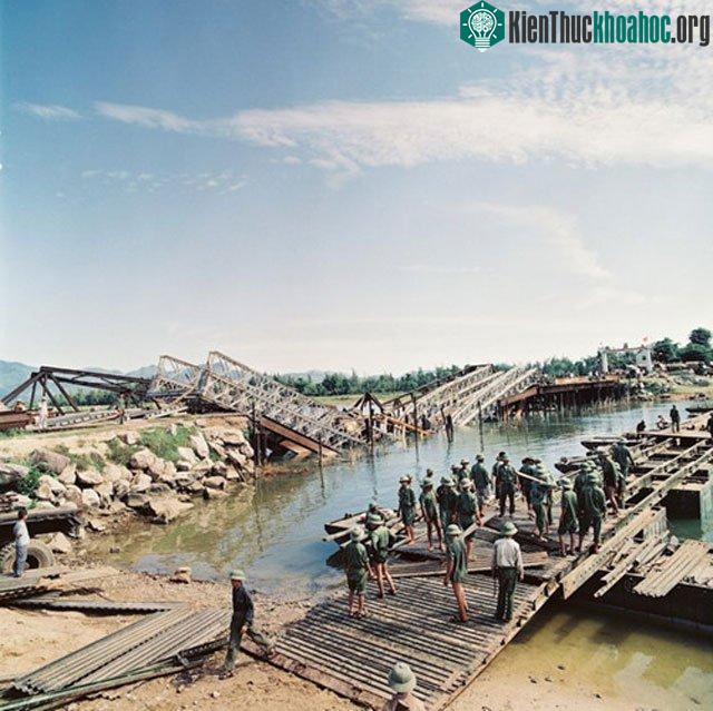 Một cầu tạm đang được dựng cạnh một cây cầu bị bom Mỹ đánh sập.