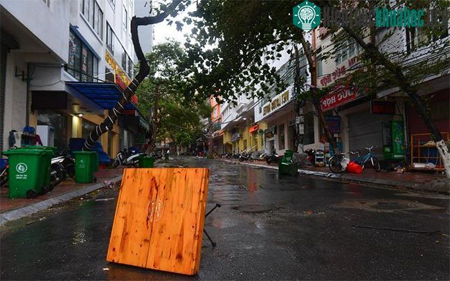 Gió giật mạnh cuốn bay một số vật dụng như bàn ghế gỗ, thùng rác để trên vỉa hè