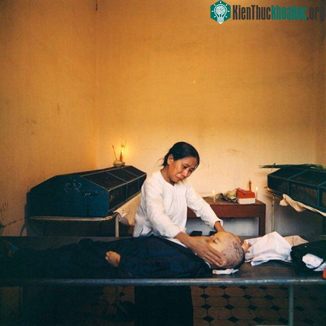 Tại nhà xác, một người bà đau đớn trước thi thể đứa cháu bị chết vì bom đạn Mỹ.