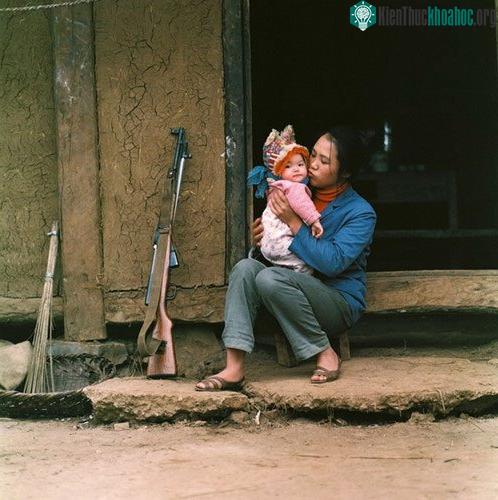 Nữ dân quân nựng yêu con nhỏ.
