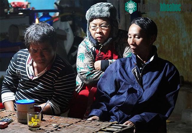 Ông Nguyễn Đúng (bìa trái) cùng các thành viên trong gia đình theo dõi diễn biến bão qua điện thoại.