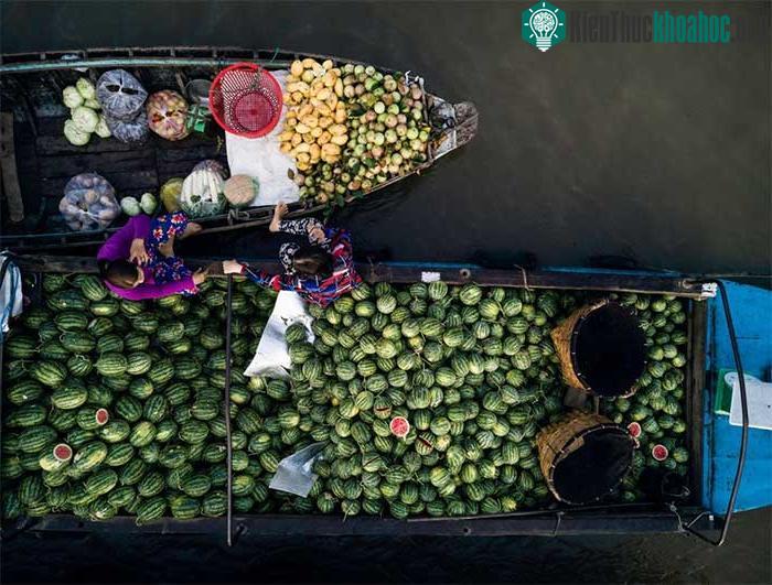 Hai cô bán hàng đang ngồi trên ghe đợi khách đến mua đồ tại chợ nổi Phong Điền, Cần Thơ.