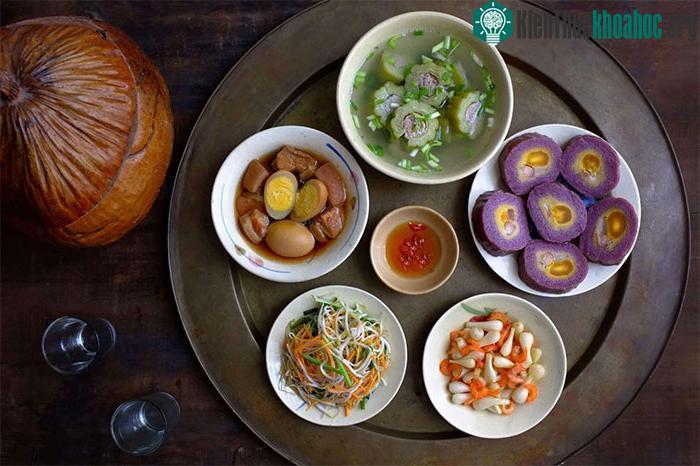 Mâm cơm Tết miền Nam có bánh Tét nhân chuối đậu, canh khổ qua, thịt kho hột vịt...