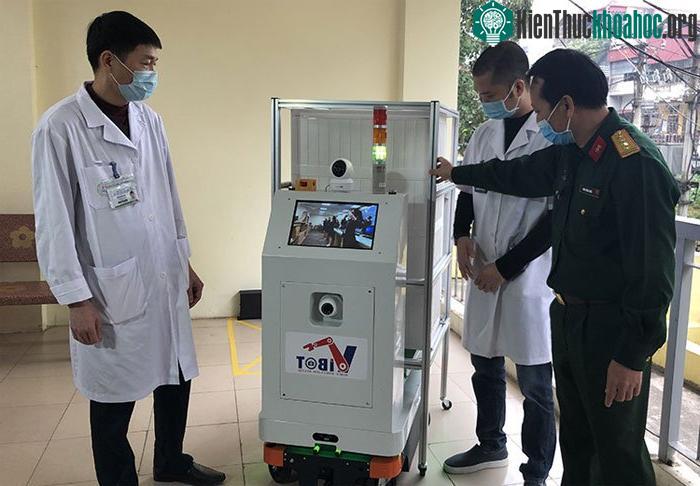 PGS.TS. Đại tá Tăng Quốc Nam, Chủ nhiệm đề tài (bìa trái) giới thiệu robot tới các bác sĩ bệnh viện Bắc Thăng Long.