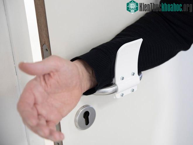 Người mở cửa bằng cánh tay để tránh tiếp xúc bằng bàn tay, giúp ngăn chặn sự lây nhiễm virus corona.