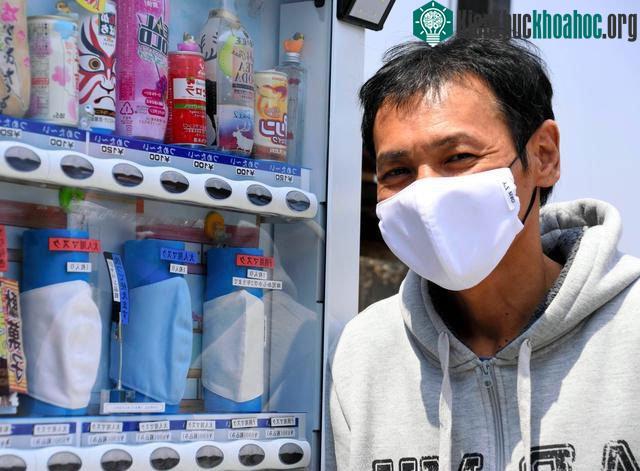 Goto đứng trước máy bán hàng tự động (Asahi Shimbun)