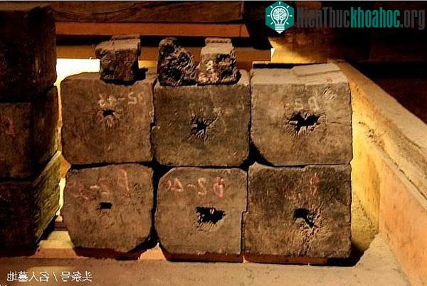 Thân cây hoàng đàn được tước vỏ, xếp vuông vức làm tường lăng mộ