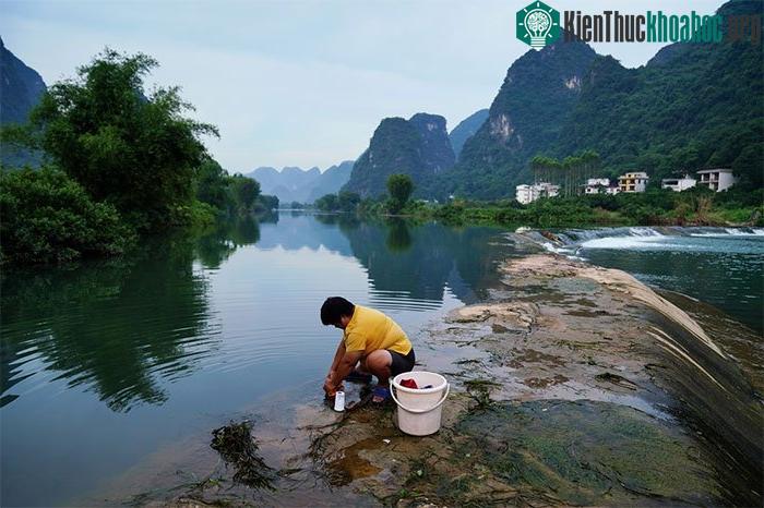 Người dân giặt quần áo tại sông Yulong, một nhánh của sông Li, tại huyện Dương Sóc ngày 17/7.