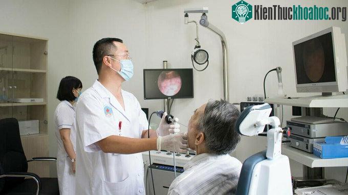 Bác sĩ Bệnh viện Hữu nghị khám họng cho người cao tuổi.