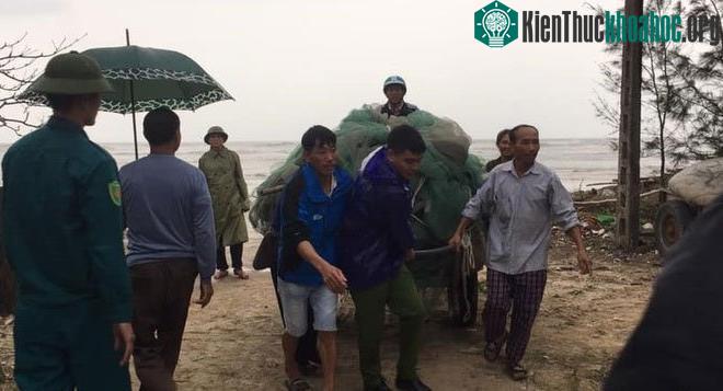 Lực lượng công an, chính quyền ở Kỳ Anh giúp người dân di chuyển ngư lưới cụ lên bờ