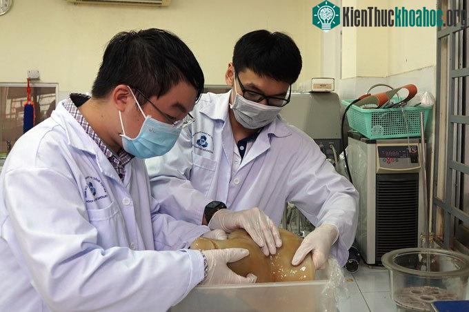 Nhóm sinh viên kiểm tra lớp màng CNC được tạo ra từ bùn giấy trong phòng thí nghiệm.