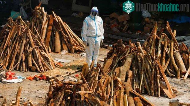 Nhân viên y tế đứng cạnh giàn hỏa táng những người chết vì bệnh Covid-1