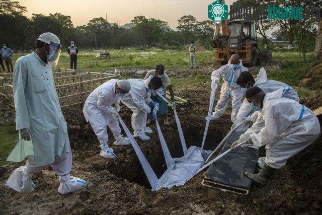 Người thân và các nhân viên mặc đồ bảo hộ để chôn cất bệnh nhân tử vong vì Covid-19