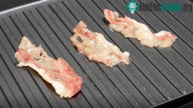Bomb_tamio đang nướng một vài miếng thịt xông khói mỏng.