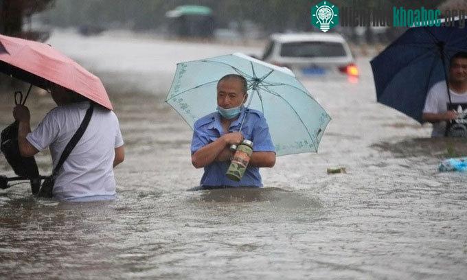 Người dân lội trong nước lũ ở Trịnh Châu.