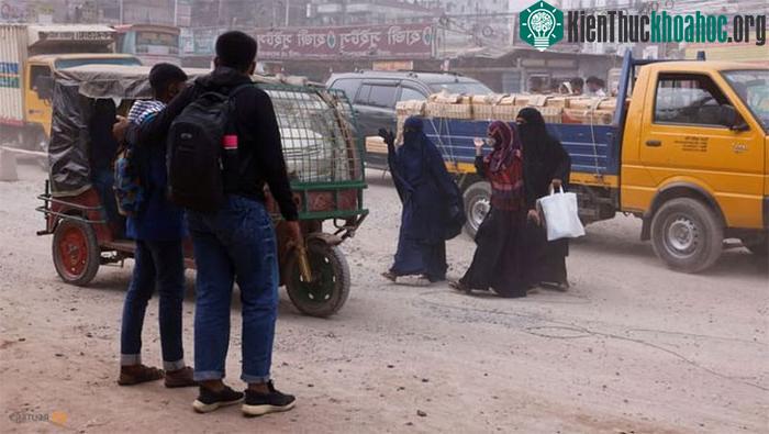 Người dân Bangladesh đang băng qua một con đường đầy bụi do ô nhiễm không khí
